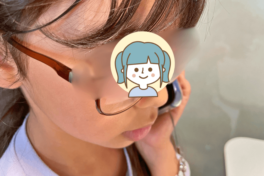 キッズ携帯を耳に当てて真剣に聞いているところ