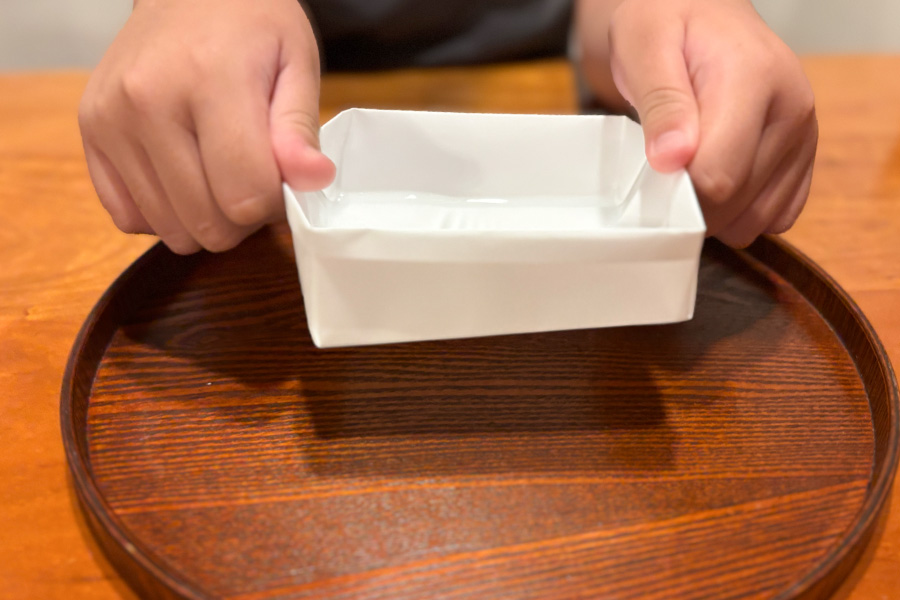 非常用食器折り紙で作った箱に熱湯を入れて、それを持ち上げた様子