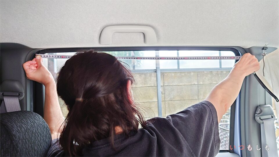 女性が車内の窓のサイズを測っている様子