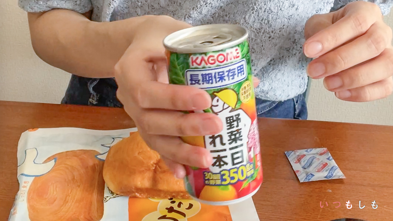 「野菜一日これ一本」を持っている手