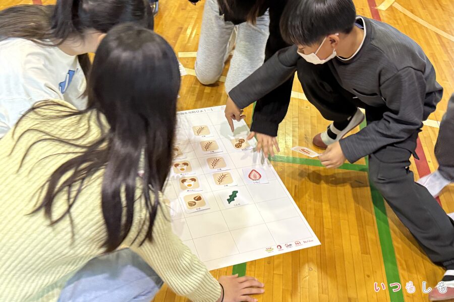 模造紙にカードを貼る子ども達